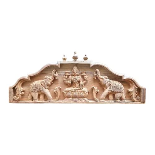 Gajalakshmi wall panel teakwood finish Gajalakshmi with Gopuram teak wood wall panel displayed above entrance in a traditional Indian home